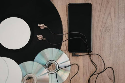 Retro and digital music devices on wooden surface