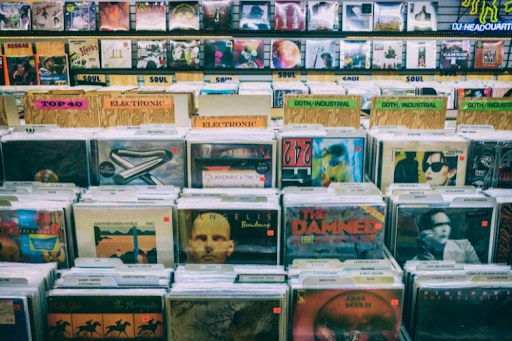 Vinyl records organized by genre in a record store display.